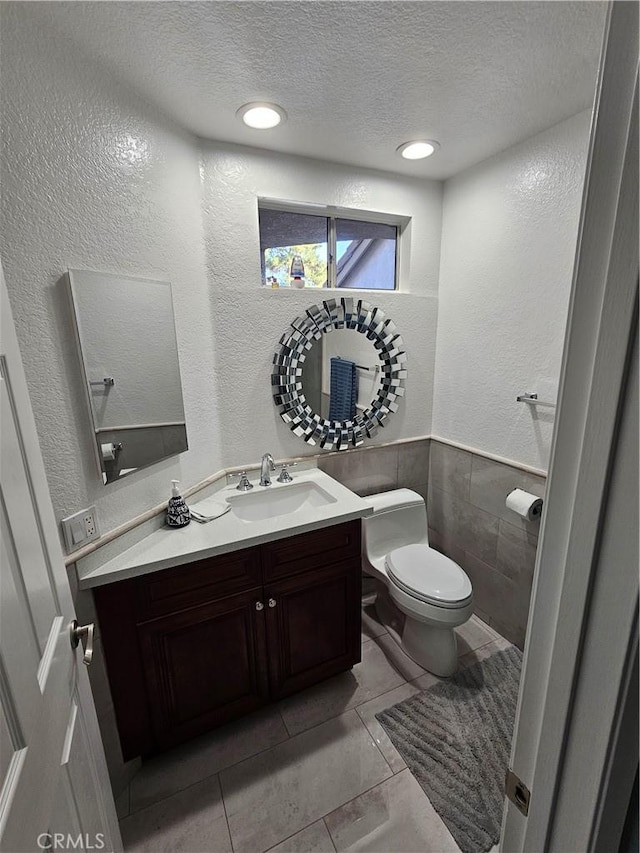 24377 Larchmont Ct Unit 32, Laguna Hills, CA 92653 - half bath with a textured ceiling, a textured wall, vanity, tile patterned flooring, and tile walls