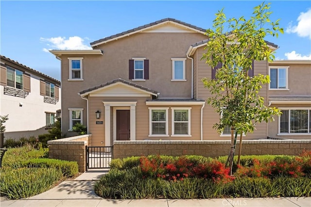 5603 Kate Way Unit 4, Fontana, CA 92336 - view of front facade with a gate, a fenced front yard, and stucco siding