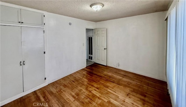 1526 Lakme Ave, Wilmington, CA 90744 - unfurnished bedroom featuring a textured ceiling, wood finished floors, and a closet