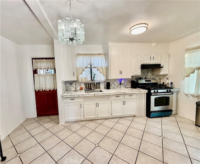 1526 Lakme Ave, Wilmington, CA 90744 - kitchen featuring stainless steel gas stove, under cabinet range hood, a chandelier, and white cabinetry