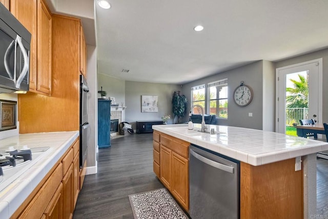 756 River Rock Rd, Chula Vista, CA 91914 - kitchen featuring stainless steel appliances, a glass covered fireplace, open floor plan, dark wood-style floors, and recessed lighting