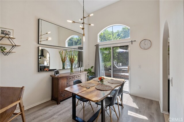 136461/2 Dronfield Ave, Sylmar, CA 91342 - dining room with a high ceiling, arched walkways, light wood-style flooring, and a chandelier