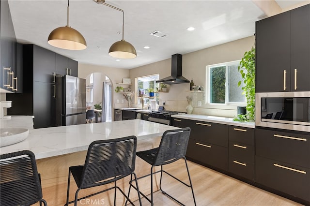 136461/2 Dronfield Ave, Sylmar, CA 91342 - kitchen with wall chimney range hood, appliances with stainless steel finishes, arched walkways, dark cabinets, and a breakfast bar