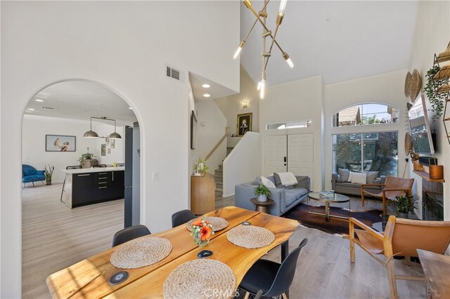 136461/2 Dronfield Ave, Sylmar, CA 91342 - dining area featuring a high ceiling, arched walkways, stairs, and light wood-style floors