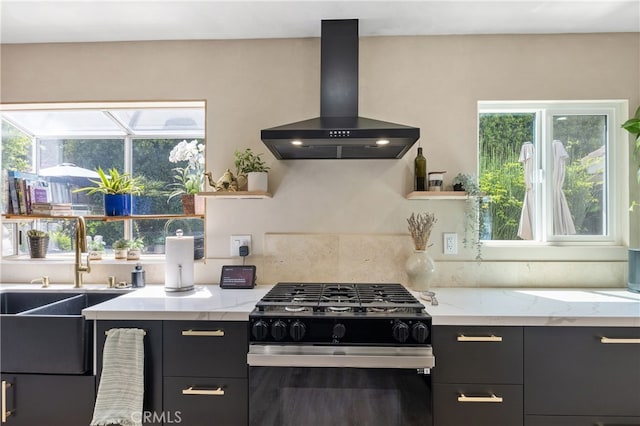 136461/2 Dronfield Ave, Sylmar, CA 91342 - kitchen with black gas range, wall chimney range hood, healthy amount of natural light, and dark cabinets