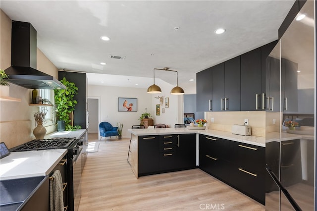 136461/2 Dronfield Ave, Sylmar, CA 91342 - kitchen with wall chimney exhaust hood, dark cabinetry, a peninsula, stainless steel range with gas stovetop, and recessed lighting