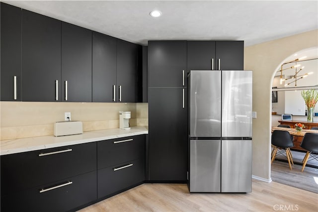 136461/2 Dronfield Ave, Sylmar, CA 91342 - kitchen with freestanding refrigerator, dark cabinets, light wood-style flooring, modern cabinets, and light stone counters