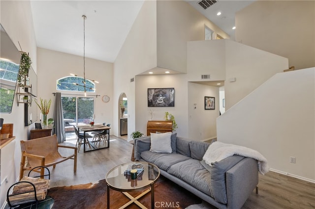 136461/2 Dronfield Ave, Sylmar, CA 91342 - living area with wood finished floors, a high ceiling, arched walkways, and a chandelier