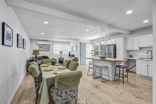 2255 Cota Ave, Long Beach, CA 90810 - dining area with a wall mounted AC, a barn door, light wood-style floors, and recessed lighting