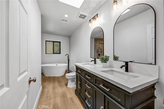 3735 Division St, Los Angeles, CA 90065 - bathroom with double vanity, wood finished floors, a freestanding tub, and a skylight