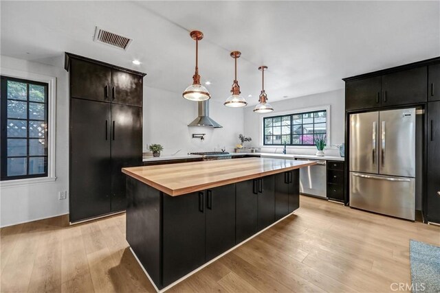 3735 Division St, Los Angeles, CA 90065 - kitchen featuring stainless steel appliances, butcher block counters, light wood-style floors, a kitchen island, and decorative light fixtures
