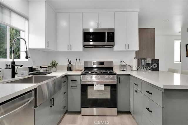 5226 W 20th St, Los Angeles, CA 90016 - kitchen featuring stainless steel appliances, a peninsula, gray cabinetry, and white cabinetry