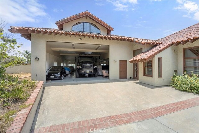 7580 E Martella Ln, Anaheim Hills, CA 92808 - rear view of property featuring stucco siding, driveway, a tiled roof, and an attached garage