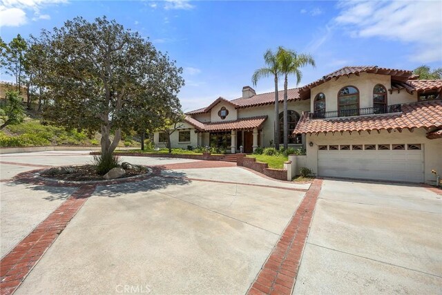 7580 E Martella Ln, Anaheim Hills, CA 92808 - mediterranean / spanish house with concrete driveway, stucco siding, a chimney, and a tile roof