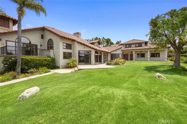 7580 E Martella Ln, Anaheim Hills, CA 92808 - rear view of house with a chimney, stucco siding, a yard, a tile roof, and a patio