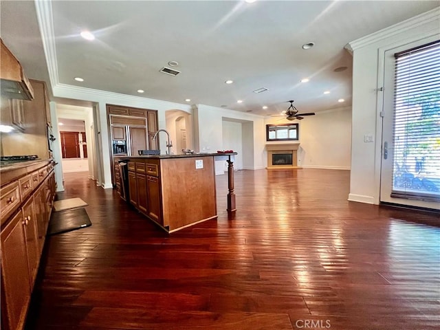 6715 Meriwether Ct, Rancho Cucamonga, CA 91701 - kitchen with ceiling fan, a breakfast bar, dark countertops, ornamental molding, and an island with sink
