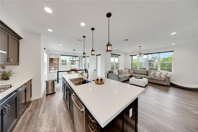 23 Vasto St, Rancho Mission Viejo, CA 92694 - kitchen featuring light wood finished floors, stainless steel dishwasher, recessed lighting, a center island with sink, and light countertops