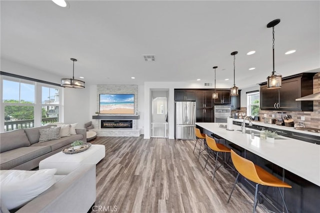 23 Vasto St, Rancho Mission Viejo, CA 92694 - living room featuring wood finished floors, recessed lighting, and a large fireplace