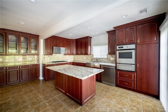 1038 N Columbus Ave, Glendale, CA 91202 - kitchen featuring stainless steel appliances, a warming drawer, reddish brown cabinets, and recessed lighting