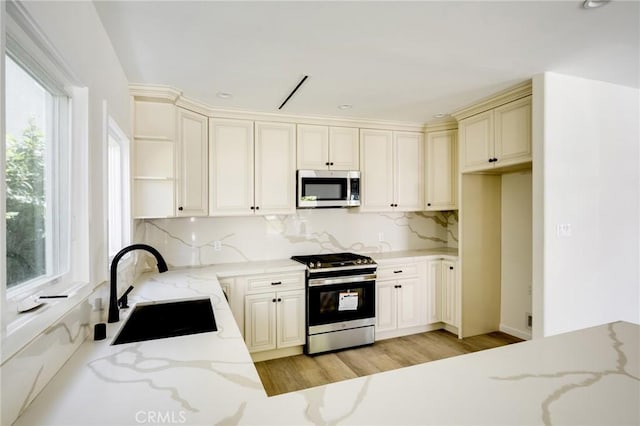 1038 N Columbus Ave, Glendale, CA 91202 - kitchen featuring appliances with stainless steel finishes, open shelves, backsplash, light stone counters, and light wood-type flooring
