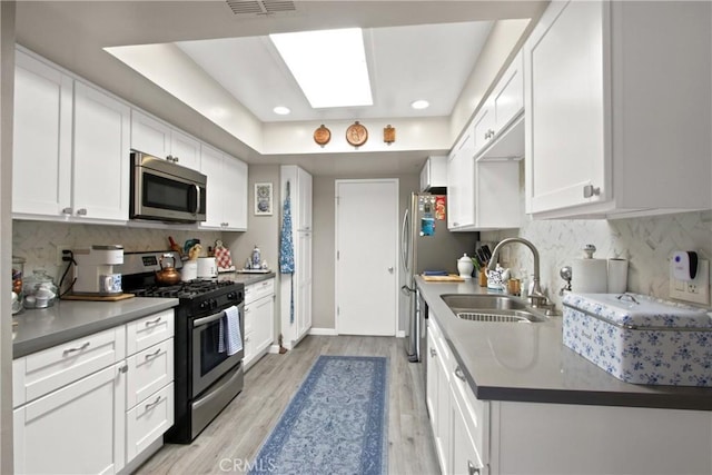 30828 Calle Chueca, San Juan Capistrano, CA 92675 - kitchen featuring appliances with stainless steel finishes, light wood-type flooring, white cabinets, tasteful backsplash, and recessed lighting