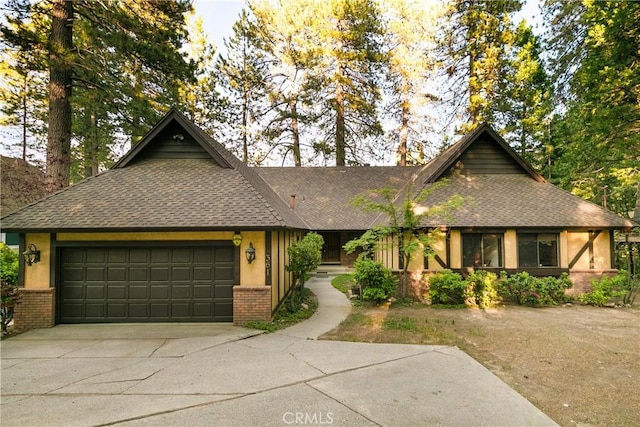 361 Riviera Dr, Lake Arrowhead, CA 92352 - view of front of home featuring brick siding, an attached garage, concrete driveway, roof with shingles, and stucco siding
