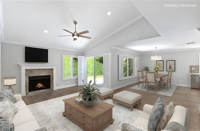 28205 Zurburan, Mission Viejo, CA 92692 - living area featuring light wood finished floors, lofted ceiling, a warm lit fireplace, a ceiling fan, and ornamental molding