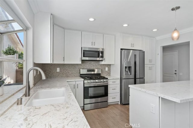 28205 Zurburan, Mission Viejo, CA 92692 - kitchen with appliances with stainless steel finishes, white cabinetry, backsplash, crown molding, and light wood-style floors