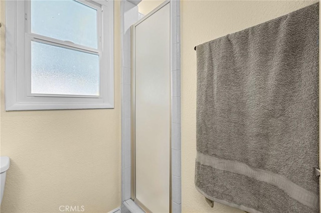 26919 Villa Ave, Highland, CA 92346 - bathroom with plenty of natural light, a shower stall, and a textured wall