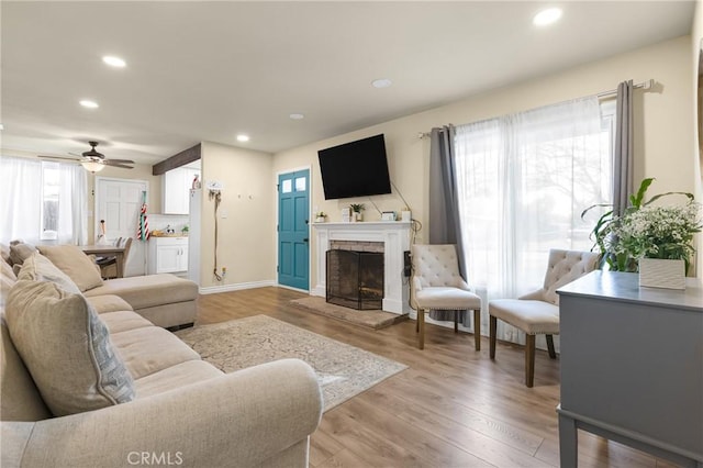 26919 Villa Ave, Highland, CA 92346 - living room with plenty of natural light, a fireplace with raised hearth, recessed lighting, light wood-style flooring, and ceiling fan