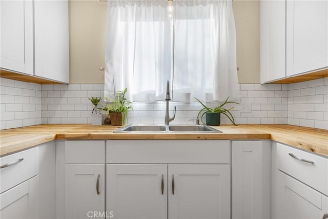 26919 Villa Ave, Highland, CA 92346 - kitchen with butcher block countertops, plenty of natural light, white cabinetry, and decorative backsplash