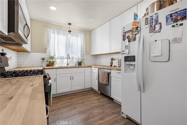 26919 Villa Ave, Highland, CA 92346 - kitchen featuring stainless steel appliances, butcher block countertops, white cabinets, wood finished floors, and decorative backsplash