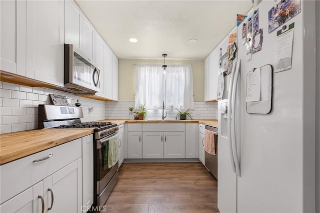 26919 Villa Ave, Highland, CA 92346 - kitchen featuring appliances with stainless steel finishes, butcher block countertops, dark wood-type flooring, white cabinets, and recessed lighting