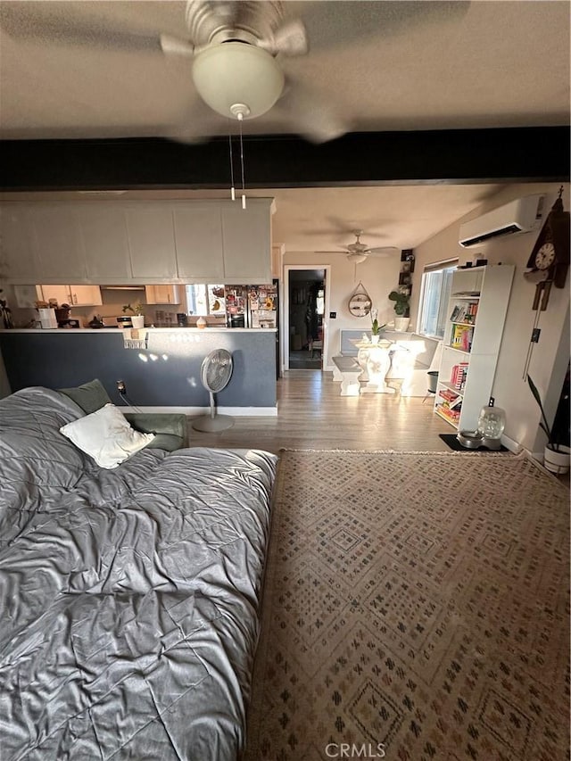 10623 4th Ave, Hesperia, CA 92345 - bedroom featuring a wall mounted air conditioner, beam ceiling, wood finished floors, and a textured ceiling