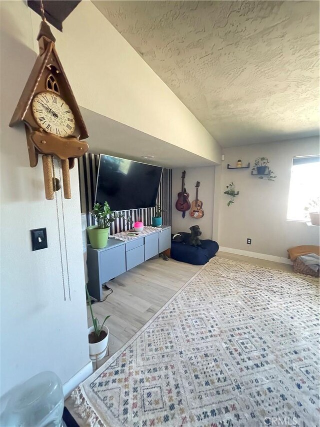 10623 4th Ave, Hesperia, CA 92345 - living room featuring a textured ceiling, lofted ceiling, and wood finished floors