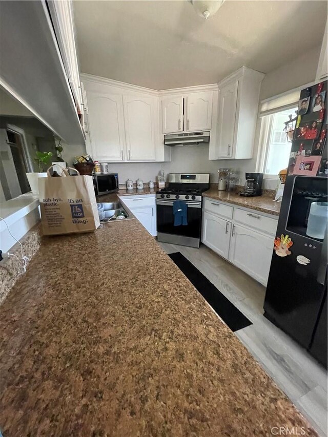10623 4th Ave, Hesperia, CA 92345 - kitchen featuring stainless steel appliances, under cabinet range hood, white cabinets, and dark stone countertops