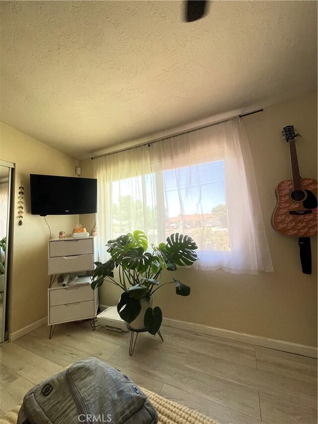 10623 4th Ave, Hesperia, CA 92345 - sitting room with healthy amount of natural light, a textured ceiling, and light wood-style flooring