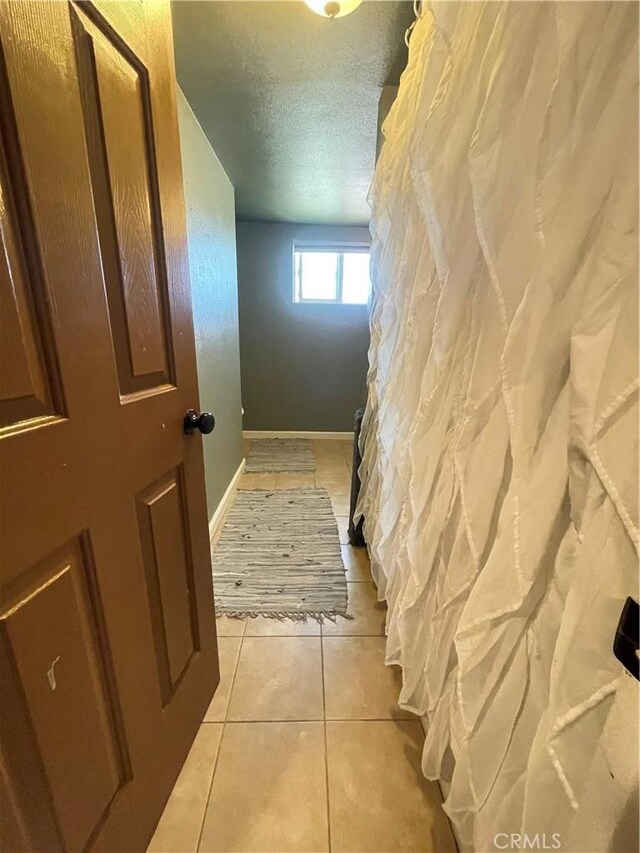 10623 4th Ave, Hesperia, CA 92345 - hallway with light tile patterned flooring and a textured ceiling