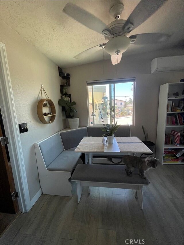 10623 4th Ave, Hesperia, CA 92345 - dining area with an AC wall unit, wood finished floors, a textured ceiling, and ceiling fan