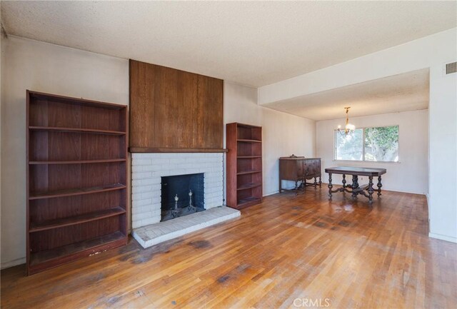 17300 Buttonwood St, Fountain Valley, CA 92708 - living area featuring wood finished floors, a chandelier, and a brick fireplace