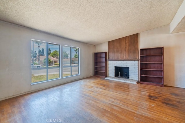 17300 Buttonwood St, Fountain Valley, CA 92708 - unfurnished living room featuring light wood finished floors, a textured ceiling, and a fireplace