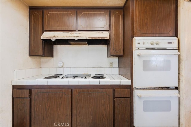 17300 Buttonwood St, Fountain Valley, CA 92708 - kitchen featuring under cabinet range hood, white appliances, and tile counters