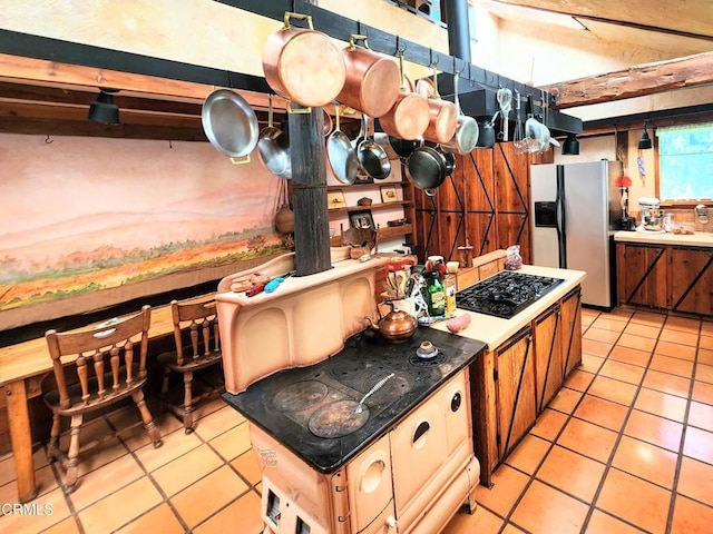 31351 Comptche Ukiah Rd, Comptche, CA 95427 - kitchen with black gas cooktop, fridge with ice dispenser, light tile patterned flooring, and brown cabinetry