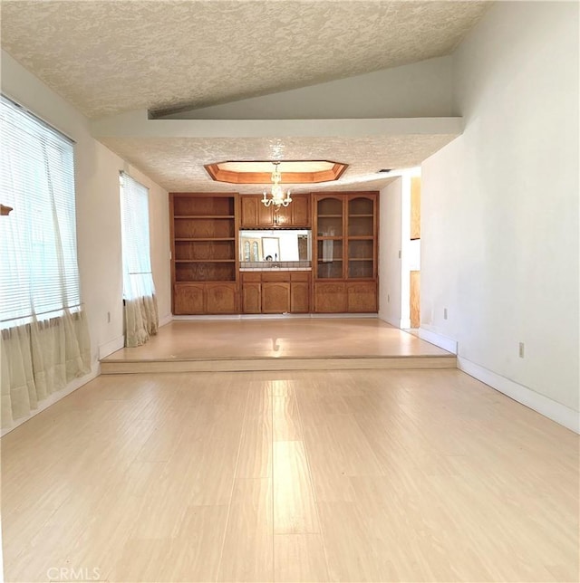 9078 Smith Rd, Phelan, CA 92371 - unfurnished living room with a textured ceiling, light wood finished floors, built in shelves, and a chandelier