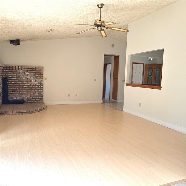 9078 Smith Rd, Phelan, CA 92371 - unfurnished living room with vaulted ceiling, wood finished floors, ceiling fan, and a textured ceiling