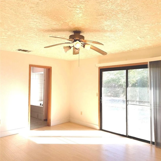 9078 Smith Rd, Phelan, CA 92371 - unfurnished room with light wood finished floors, a ceiling fan, and a textured ceiling