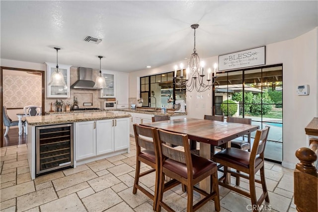5908 Alleppo Ln, Palmdale, CA 93551 - dining space with beverage cooler, a chandelier, and stone tile flooring