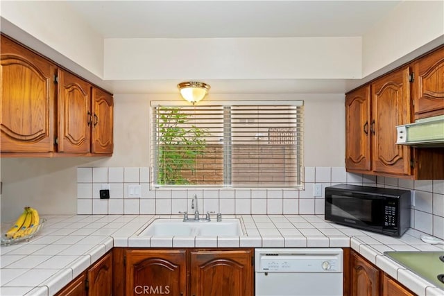 10 Mann St, Irvine, CA 92612 - kitchen with white dishwasher, black microwave, brown cabinetry, and backsplash