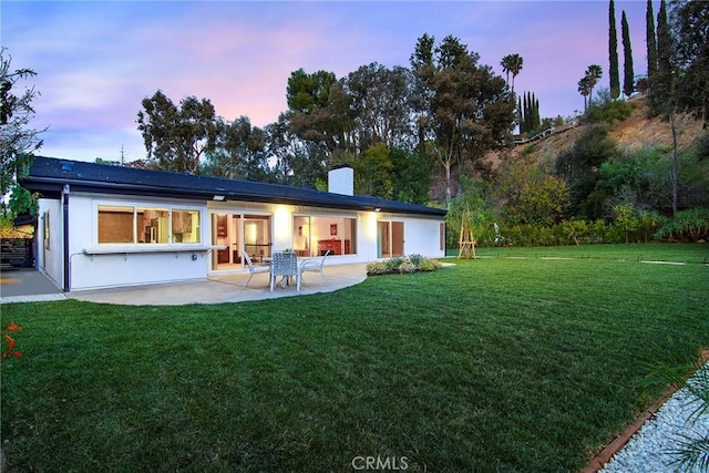 19291 Berclair Ln, Tarzana, CA 91356 - back of property featuring a patio, a lawn, a chimney, and stucco siding