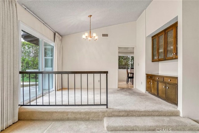 19291 Berclair Ln, Tarzana, CA 91356 - hallway featuring carpet floors, a chandelier, a textured ceiling, and vaulted ceiling